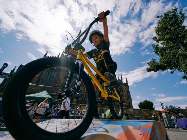 Young person riding a BMX bike over ramps