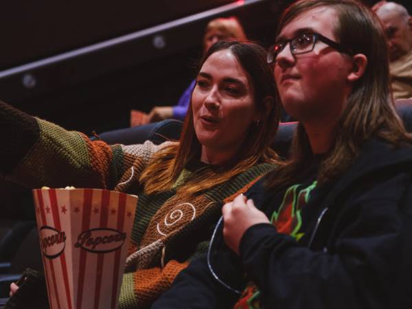 Couple sat in the cinema with popcorn