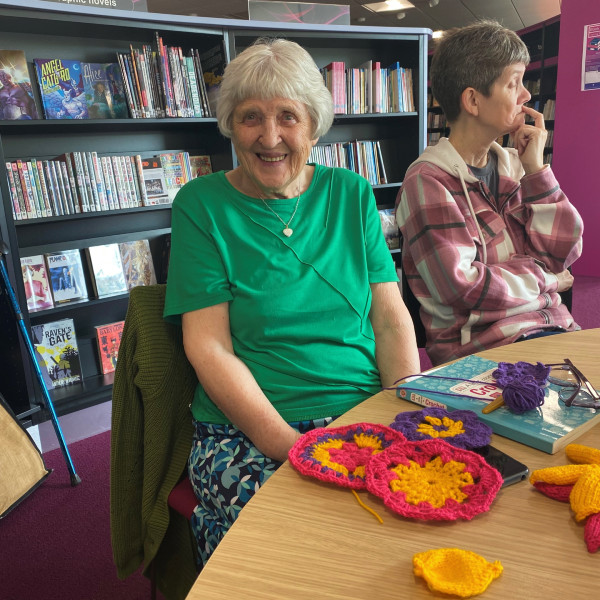 Woman knitting flowers in Riverside library